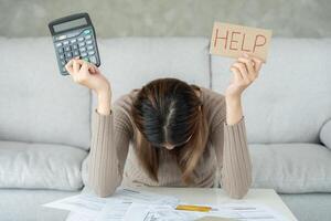 Stressed and headache asian woman with large bills or invoices no money to pay to expenses and credit card debt. shortage, Financial problems, mortgage, loan, bankruptcy, bankrupt, poor, empty wallet photo