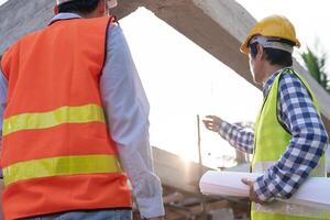 inspector or engineer is inspecting construction and quality assurance new house using a blue print. Engineer or architects or contactor work to build the house before handing it over to the homeowner photo