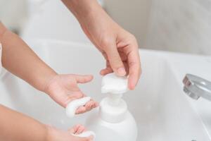 little kid hands wash with soap bubbles and rinse with clean water to prevent and stop the spread of germs after back to home, virus or covid19. Good health and good personal hygiene, virus, bacteria photo