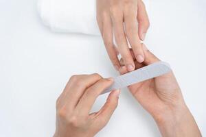 Woman receive care service by professional Beautician Manicure at spa centre. Nail beauty salon use nail file for Glazing treatment. manicurist make nail customer to beautiful. body care spa treatment photo
