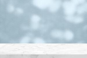 White Marble Table with Tree Shadow on Cyan Concrete Wall Texture Background photo