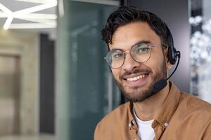 Smiling customer service representative with a headset in a modern office setting, ready to assist clients. photo