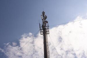 Telecommunication tower of 4G and 5G cellular. Macro Base Station. 5G radio network telecommunication equipment with radio modules and smart antennas mounted on a metal on cloulds sky background.. photo