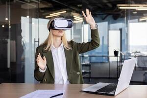 A professional businesswoman using a virtual reality headset at her desk in a contemporary office setting, demonstrating the integration of advanced technology in the workplace. photo