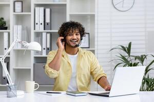 Smiling customer service representative with headset working at laptop in modern office setting, providing excellent support. photo