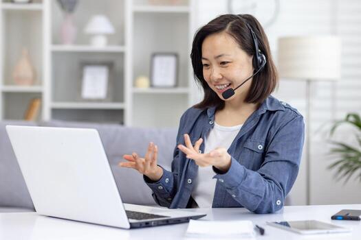 un sonriente mujer vistiendo un auriculares se involucra en un llamada en su ordenador portátil mientras trabajando desde hogar en un cómodo vivo habitación ajuste. foto