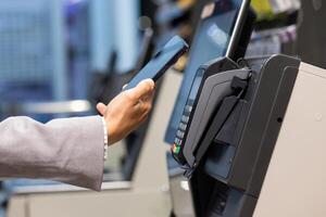 A person uses a smartphone for contactless payment at a store, offering convenience in retail with NFC technology. Its popular for safety and quick transactions, making it a modern and secure way to shop and pay photo