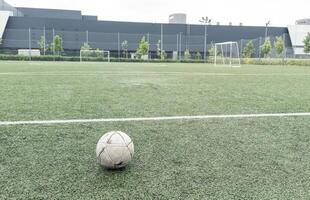 Green grass and white border lines on football ground. Soccer field on artificial turf. Artificial green grass texture. Artificial football field in an open stadium photo