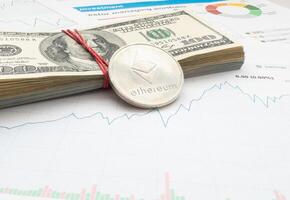 Gold ethereum cryptocurrency coin on stock market line graph trading chart. Top view. photo