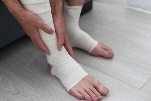 man using put on elastic bandage with legs having leg pain photo