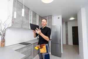 Worker with tablet computer checking alarm system indoors photo
