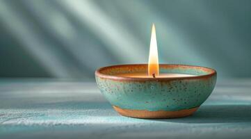 A Single Lit Candle in a Blue Setting photo