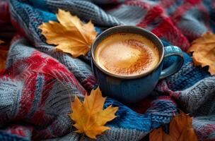A Cup of Coffee on a Knit Blanket With Autumn Leaves photo