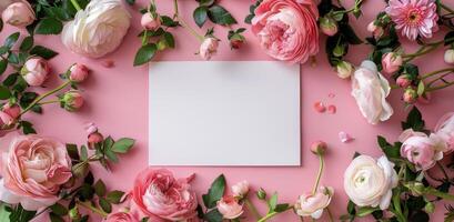 White Square Card Surrounded by Delicate Pink Roses on a Pink Background photo