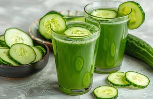 Refreshing Cucumber Juice With Sliced Cucumbers on a White Surface photo