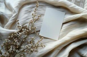 White Envelope on Cream Fabric With Dried Flowers and Sunlight Shadows photo