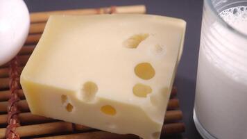 sliced cheese with holes, milk and egg on table video
