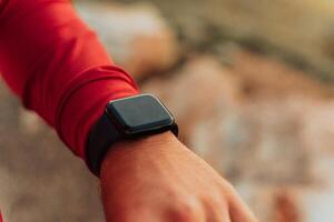 Man Using A Digital Smartwatch During Workout. Closeup View Of Man's Hands Checking An App In Smartwatch. Close-up Of A Clock That Shows Steps, Kilometers And bpm. photo