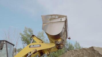 Serbia, Belgrade - May 7, 2022. Side view of a mining truck with its bucket loaded with sand. Scene. Heavy industry and machinery concept, industrial background at the quarry. video