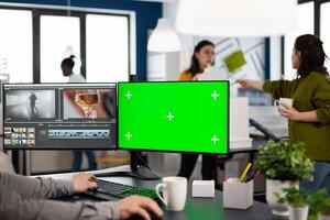 maker editing movie using post production software working in creative agency at pc with green screen, chroma key, mock up isolated display. Videographer processing audio film montage photo