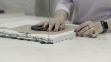 A skilled tailor cuts fabric with a bandsaw for precise tailoring outcomes in the workshop video