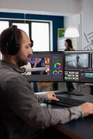 Graphic production working on pc with two displays editing and audio footage sitting in creative workplace. maker employee processing film montage in digital multimedia company photo