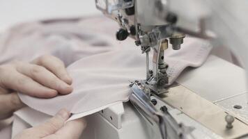 Skilled hands use a sewing machine in a textile workshop to stitch fabric with precision video