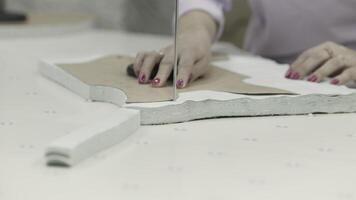 Garment fabric cutting is done in a workshop using hands and tools with precision and craftsmanship video