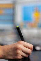 Close up of photo editor freelancer editing customer photo using computer with two displays drawing on graphic tablet. Graphic photographer retouching assets in creative agency with stylus pencil
