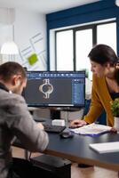 Coworkers engineer architects working on modern cad program developing construction metalic components. Industrial designer studying prototype idea on pc showing digital software with gears photo