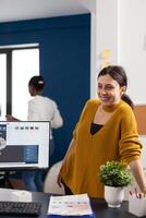 Industrial architect colleagues working and having fun sharing ideas for new mechanical project. Engineers using pc with CAD software and two monitors in start up company innovating motor prototype. photo