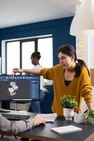 Team discussing about industrial project using dual monitors setup to desing 3D gears and metalic clamp in CAD software. Woman industrial engineer project manager working in creative office photo