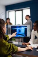 Gamer creator explaning to african worker how testing game level interface, developing new design in creative office pointing at screen. Player online games with technology network wireless. photo