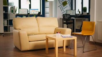 Interior of empty creative office with dusky light, new business, start up company with no people in it. Company with modern design and confortable couch with nobody in it, place of work startup photo