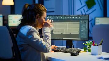 Freelancer architect working in 3D software to elaborate container design sitting at desk in business office at midnight. Focused engineer creating and studying prototype, analysing scale model. photo