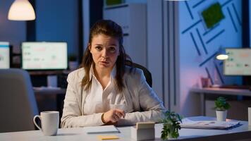Pov of businesswoman having a conference with team during midnight looking in camera in workplace. Lady using modern technology network wireless talking on virtual meeting at doing overtime photo