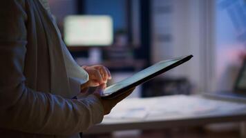 Close up of woman employee texting, sending and reading messages during break standing in business office late at night. Businesswoman using modern technology network wireless overworking in midnight photo