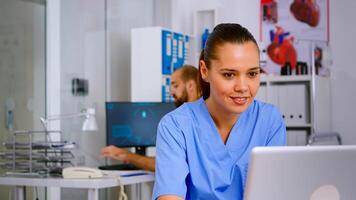 Man medical practitioner answering phone calls and scheduling appointments woking in background. Healthcare physician in medicine uniform, receptionist assistant helping with telehealth communication photo