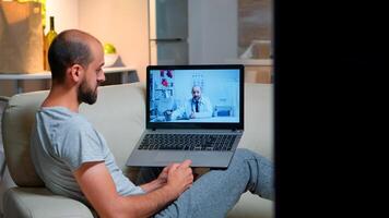 Sick man having online telemedicine consultation during covid-19. Caucasian male sitting in front of laptop disscusing with medical physician about illness symptoms working on healthcare treatment photo