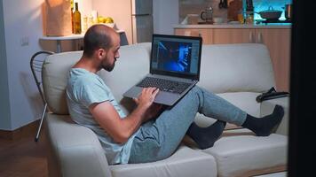 Professional game developer working on gameplay and game level late at night from the confort of his home. Professional creative man in the evening developing startup technology photo