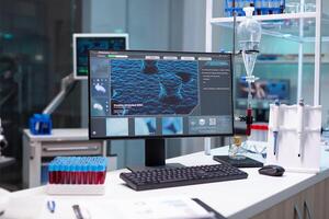 Computer with microbiology virus expertise on display standing on table during medicine biochemistry genetic experiment in pharmaceutical hospital laboratory. Healthcare treatment development photo
