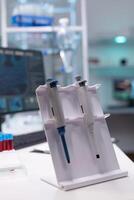 Medical micropipette standing on table ready for microbiology scientific test experiment in biology science hospital laboratory. Clinical biological instrument. Healthcare investigation photo