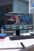 Computer with microbiology researcher developing on display standing on table in biochemistry pharmaceutic hospital laboratory. Medical scientific virus discovery experiment. Healthcare expertise photo