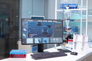 Computer with microbiology virus expertise on display standing on table during medicine biochemistry genetic experiment in pharmaceutical hospital laboratory. Healthcare treatment development photo