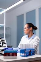 Microbiology scientist typing biochemistry discovery experiment at computer using medical high tech working in pharmacology hospital laboratory.Biology doctor developing virus treatment expetise photo