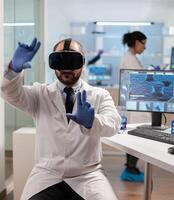 Professional scientist using medical inovation in lab wearing virtual reality glasses. Team of researchers working with equipment device, future, medicine, healthcare, professional, vision, simulator. photo