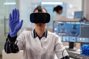 Close up of scientist using vr goggles augmented reality for vaccine development. Team of researchers working with equipment device, future, medicine, healthcare, professional, vision, simulator. photo
