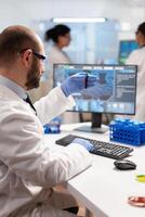 Genetic scientist studying epidemics holding sample of blood in test tube. Viorolog in professional lab analysing vaccine evolution, using modern technology, epidemics, health innovation. photo