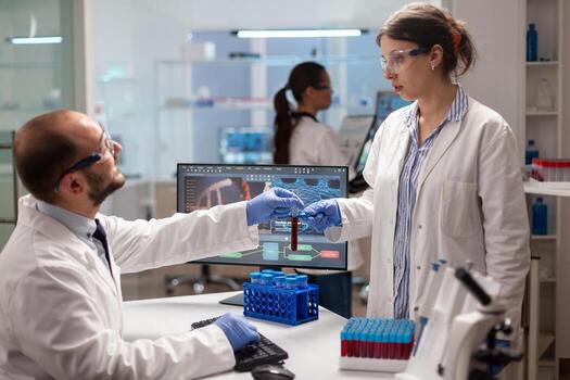 Biochemistry reserarchers doing experiments with blood sample for vaccine development. Medical scientist working with DNA scan image in modern equipped laboratory using high tech technology. photo