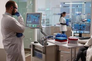 Medical researcher in scientific laboratory analyzing dna sample. Chemical scientis analyzing vaccine on screen examining vaccine development using high tech researching treatment. photo